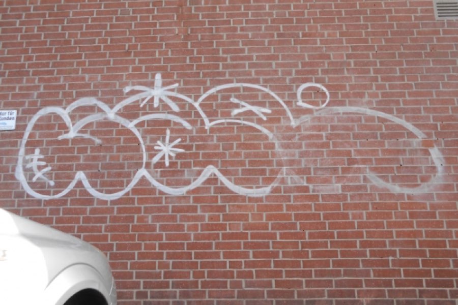 Brick façade with graffiti before laser cleaning